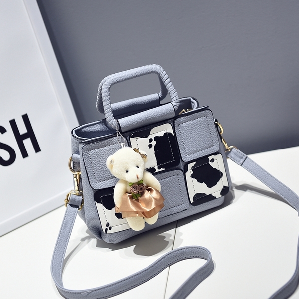 Μια μικρή τσάντα με αξεσουάρ αρκούδα σε γκρι, κόκκινο, μπλε, μοβ και ροζ