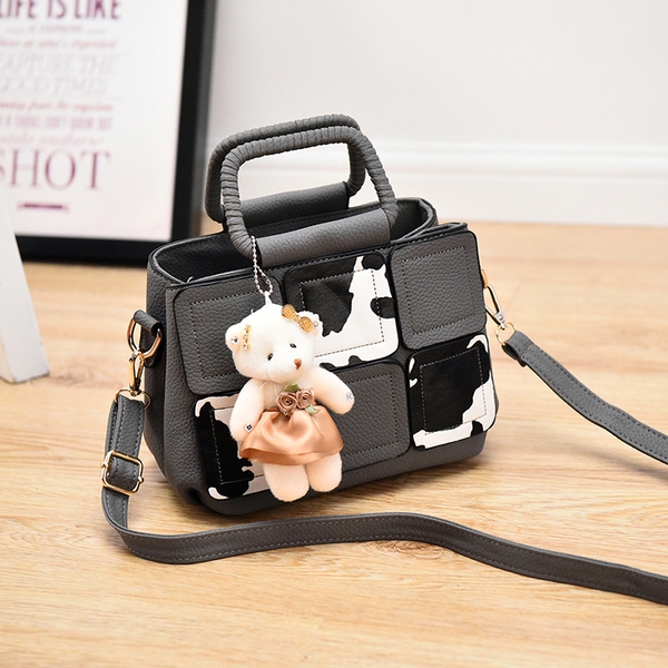 Μια μικρή τσάντα με αξεσουάρ αρκούδα σε γκρι, κόκκινο, μπλε, μοβ και ροζ