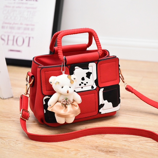 Μια μικρή τσάντα με αξεσουάρ αρκούδα σε γκρι, κόκκινο, μπλε, μοβ και ροζ