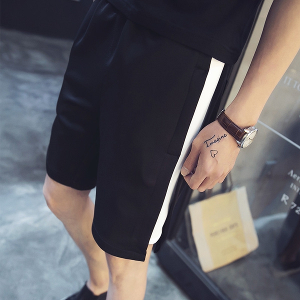 Καλοκαιρινό σύντομο μαύρο παντελόνι ανδρών και η ζωή στην παραλία