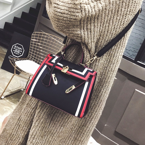 Стилна дамска чанта в черно и бяло с интересно закопчаване. 