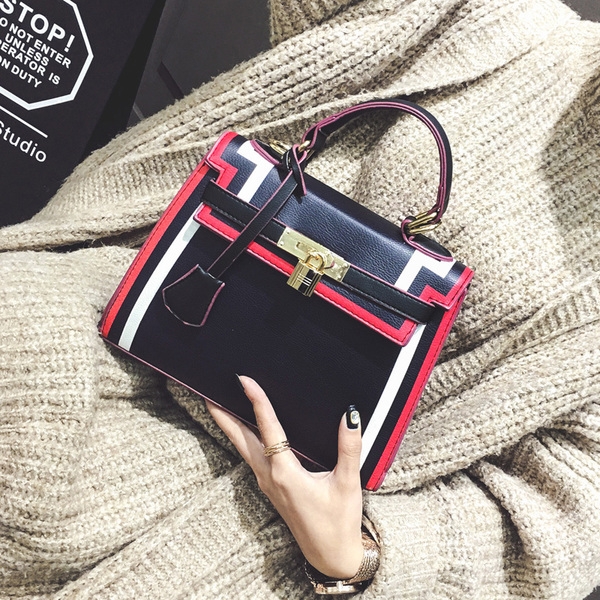 Стилна дамска чанта в черно и бяло с интересно закопчаване. 