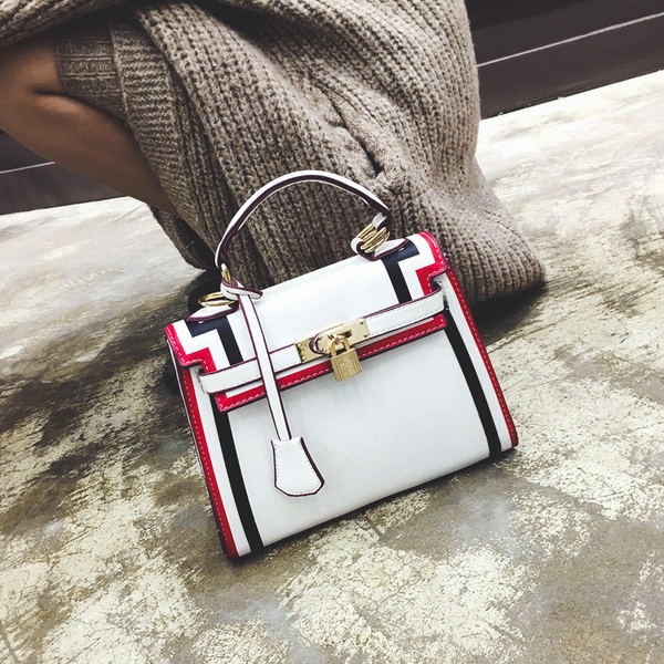 Стилна дамска чанта в черно и бяло с интересно закопчаване. 