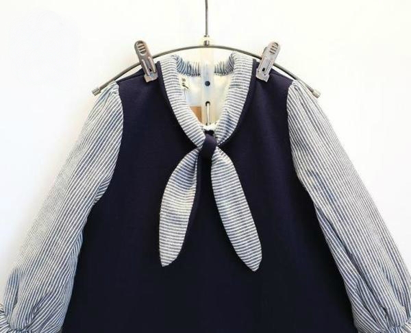 Παιδικό φόρεμα με μπλε κορδέλα στο μπροστινό μέρος.