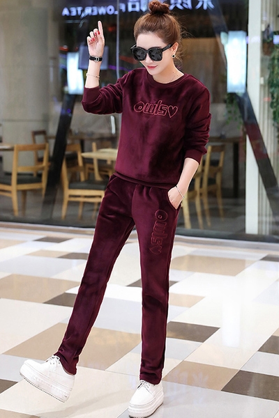 Οι γυναίκες βελούδινα φόρμα σε μπορντό και το μαύρο με την επιγραφή.