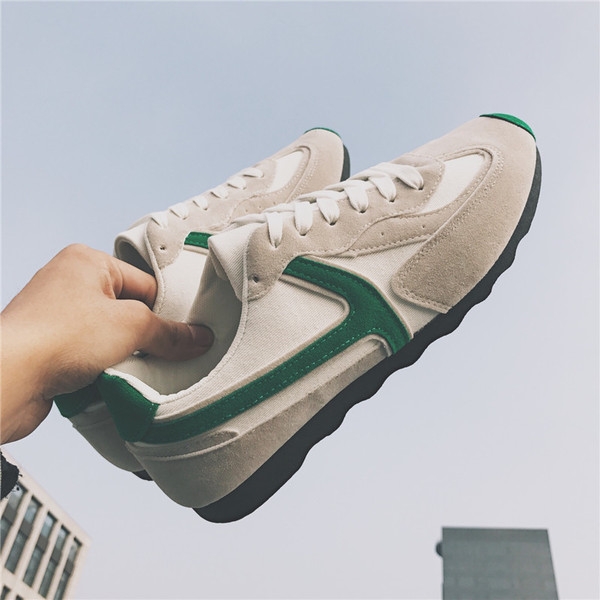 Πάνινα παπούτσια των ανδρών σε μαύρο και μπεζ με πράσινο και λευκές ρίγες.