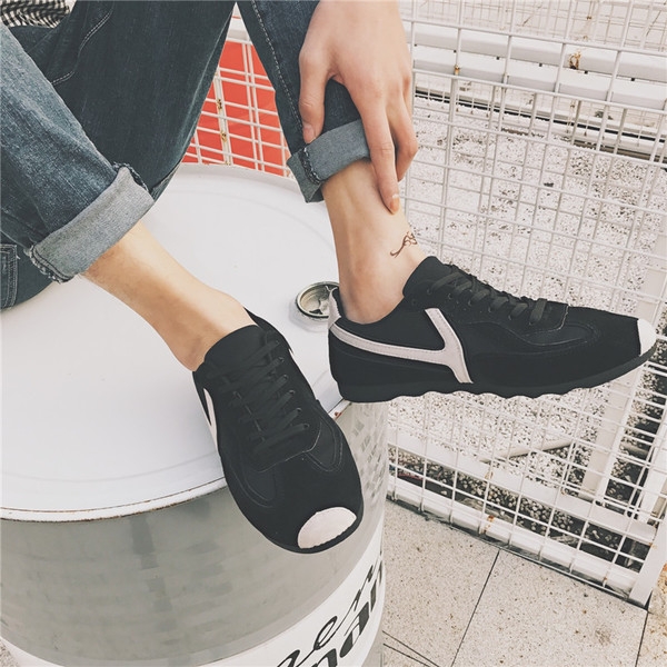 Πάνινα παπούτσια των ανδρών σε μαύρο και μπεζ με πράσινο και λευκές ρίγες.