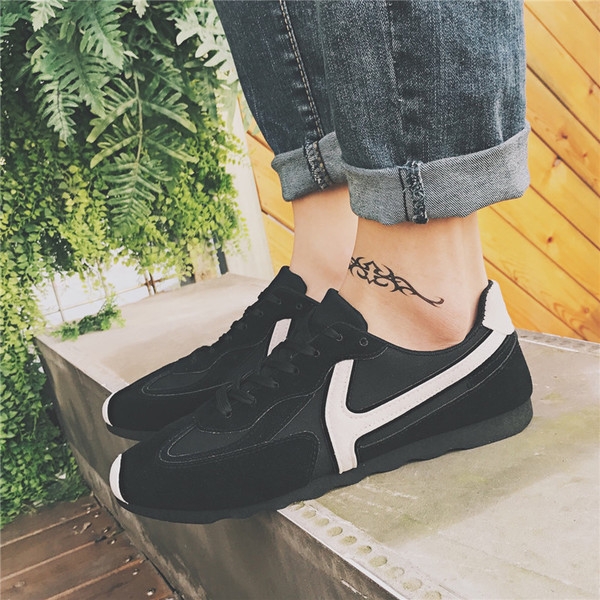 Πάνινα παπούτσια των ανδρών σε μαύρο και μπεζ με πράσινο και λευκές ρίγες.