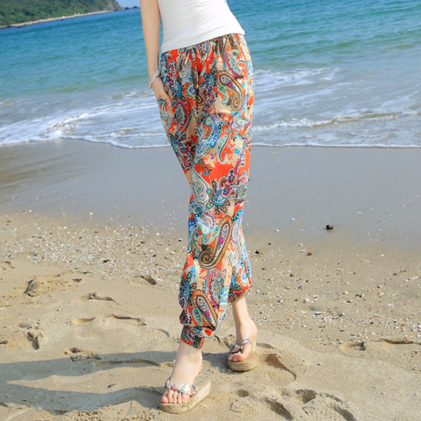 Οι γυναίκες μποέμ μακρύ και ευρύ παντελόνι παραλία το καλοκαίρι σε δύο floral μοτίβο με preobladyavashto μπλε ή πορτοκαλί