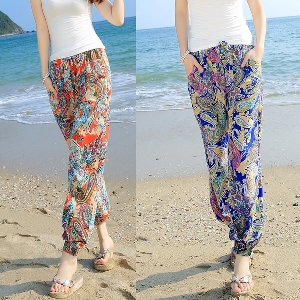 Οι γυναίκες μποέμ μακρύ και ευρύ παντελόνι παραλία το καλοκαίρι σε δύο floral μοτίβο με preobladyavashto μπλε ή πορτοκαλί
