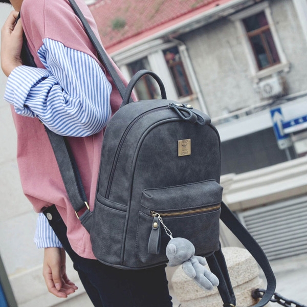 Απλό γυναικείο  σακίδιο με διπλό φερμουάρ και ένα μικρό αρκουδάκι στην μπροστινή τσέπη.