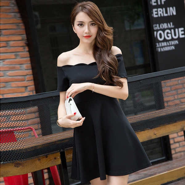 Κυρίες κομψό μαύρο φόρεμα με γυμνά ώμους και ελαφρώς φούντωσε από τη μέση και κάτω